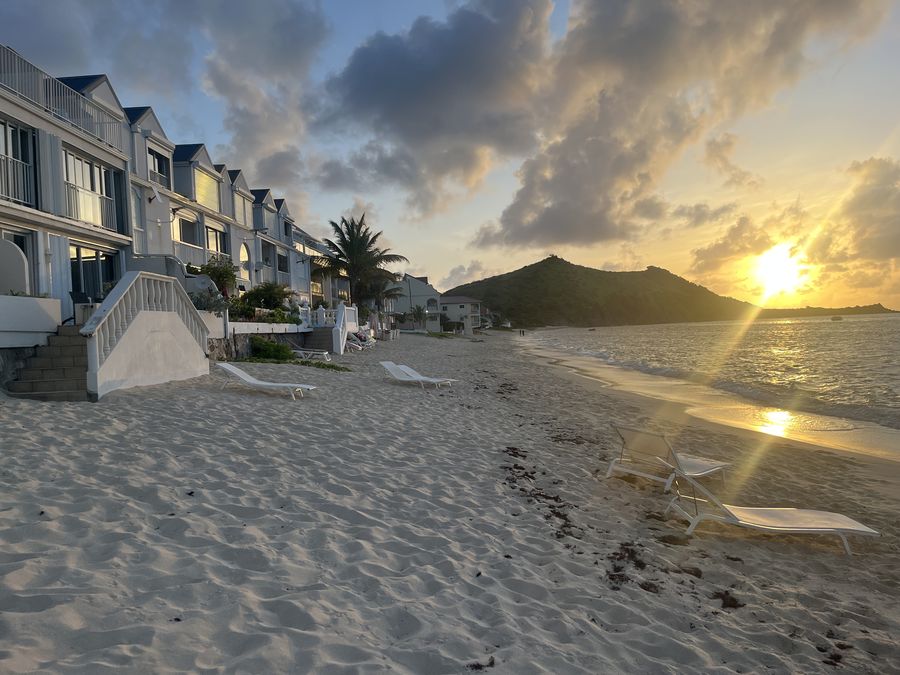 Sunset over Grand Case beach, Saint Martin, with sun loungers on the sand
